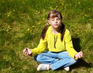 Child meditating in park