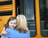 Mum hugging little girl goodbye at school bus Mum hugging little girl goodbye at school bus