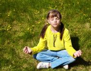 Child meditating in park Child meditating in park