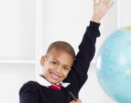 Child raising hand in classroom Child raising hand in classroom