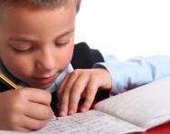 Close up of boy practising writing Close up of boy practising writing