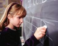 Girl practising writing on blackboard Girl practising writing on blackboard