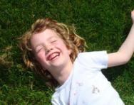 Girl lying on grass laughing Girl lying on grass laughing