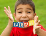 Boy holding blocks spelling 'play' Boy holding blocks spelling 'play'