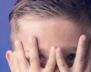 Boy hiding behing his hands Boy hiding behind his hands