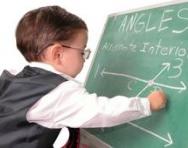 Child genius doing maths at blackboard