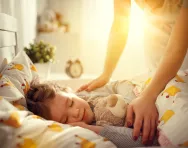 Parent tucking child into bed Parent tucking child into bed