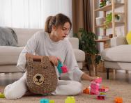 Mother picking up toys in empty house