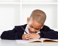 Child happily writing in school book