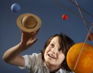 Boy looking at solar system model