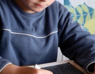 Boy writing maths on blackboard