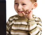 Boy smiling at computer Boy smiling at computer