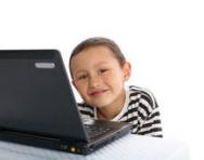 Boy smiling sitting at computer