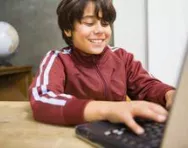 Boy smiling at computer Boy smiling at computer