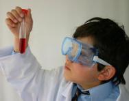 Boy wearing goggles holding test tube