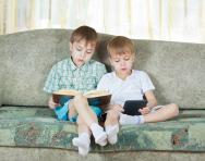 Boys reading printed book and ebook