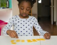Primary-school maths aids: child counting pasta shapes