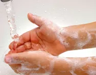 Child washing hands at sink