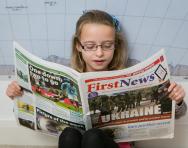 Child reading a newspaper
