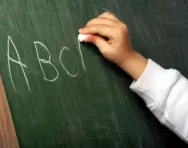 Child writing letters on blackboard Child writing letters on blackboard