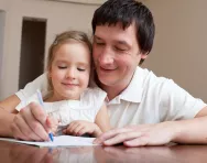 Dad and child writing together