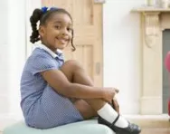 Girl in uniform doing up her shoes Girl in uniform doing up her shoes
