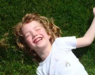 Girl lying on grass laughing Girl lying on grass laughing