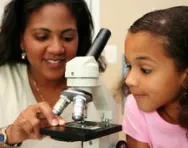 Girl and teacher using microscope Girl and teacher using microscope