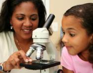 Girl and teacher using microscope