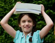 Child balancing a book on her head