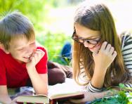 Children reading outdoors