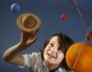 Boy looking at solar system mobile