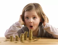 girl looking at pile of coins girl looking at pile of coins