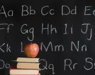 Alphabet on blackboard and apple on book Alphabet on blackboard and apple on book