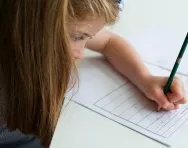 Girl filling in SATs paper Girl filling in SATs paper