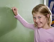 Year 4 girl doing maths on blackboard Year 4 girl doing maths on blackboard