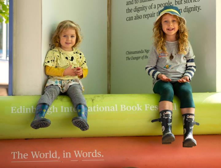 Kids sitting on giant books 