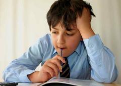 Boy puzzling over book