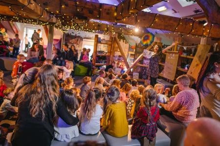 Group of children and adults sitting at story time in the museum 